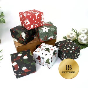 May include: A collection of small, square gift boxes with various Christmas-themed patterns. Designs include reindeer, floral, gnomes, and stockings. The boxes are in red, green, black, and white. A gold circle displays "18 PATTERNS".