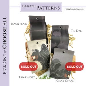 Może przedstawiać: Cztery prostokątne papierowe zawieszki z metalowymi oczkami, z wzorami o nazwach Black Plaid, Tie Dye, Tan Ghost i Gray Ghost. Zawieszki Tan Ghost i Gray Ghost mają czerwone etykiety Sold Out. Tekst zawiera Beautiful Patterns i Pick One or Choose All.
