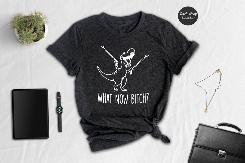 a t - shirt that says what now sits next to a briefcase