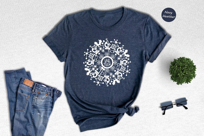 May include: A navy heather t-shirt with a white design of a circle with science lab equipment and the text "Lab Tech".