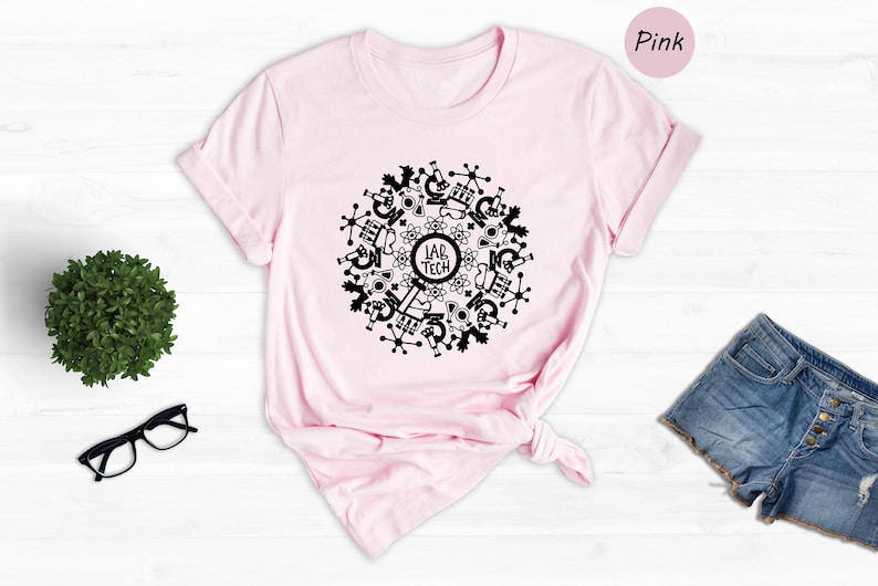 May include: A pink t-shirt with a black design of a circle with science-related icons and the text "Lab Tech" in the center.