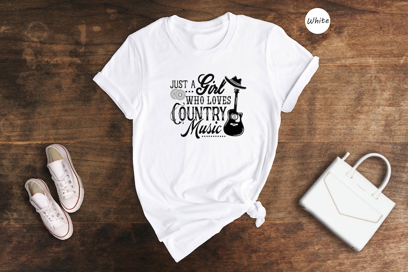 May include: White t-shirt with a black graphic that says "Just a Girl Who Loves Country Music" with a guitar and a cowboy hat.