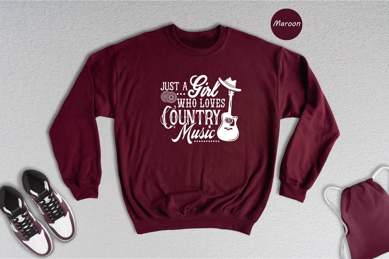 May include: Maroon sweatshirt with a white graphic that says "Just a Girl who loves Country Music" with a guitar and cowboy hat.