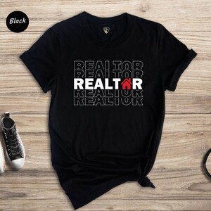 May include: Black t-shirt with the word "REALTOR" repeated in white text with a red house icon in the centre.