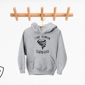 May include: Gray hooded sweatshirt with a black graphic of a tornado and the text "Tiny Human Tornado".