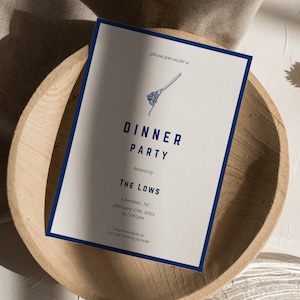 Op de afbeelding: Een witte uitnodiging met een blauwe rand, met een eenvoudige illustratie van een garde. De tekst luidt "Sluit je aan bij ons voor een diner georganiseerd door The Lows, Charlotte, NC, 17 februari 2021 om 19:00 uur".