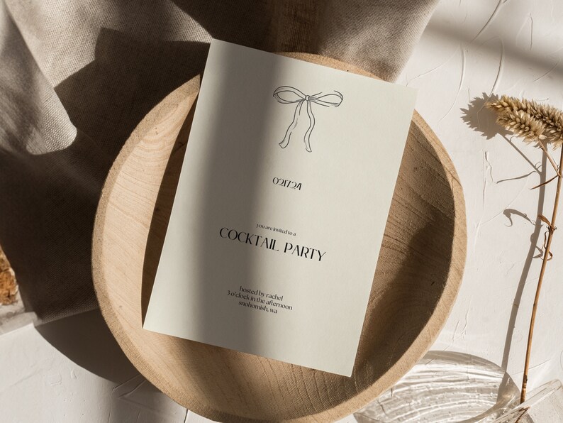 May include: A simple, minimalist invitation card with a hand-drawn bow at the top. The text reads "You are invited to a Cocktail Party" and "Hosted by Rachel 7 o'clock in the afternoon somewhere, usa"