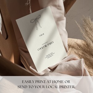 May include: A white card with a black bow illustration and the text "Cocktail Party" printed on it. The card is sitting on a light brown surface.
