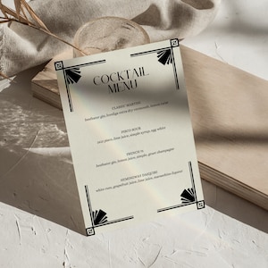 May include: A vintage-style cocktail menu with a black and white art deco design. The menu lists classic cocktails like the Classic Martini, Pisco Sour, French 75, and Hemingway Daiquiri.