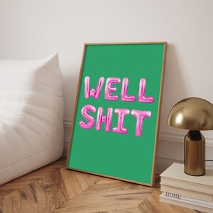 以下が含まれることがあります： 緑色の背景にピンクの風船文字で「WELL SHIT」と書かれた額装されたプリントです。