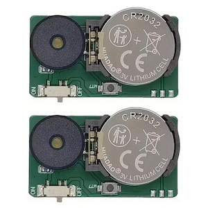 May include: Two small electronic circuit boards with a green base. Each board has a black speaker, a CR2032 3V lithium cell battery, and an on/off switch. The battery has the text "HLLADAO® 3V LITHIUM CELL" printed on it.