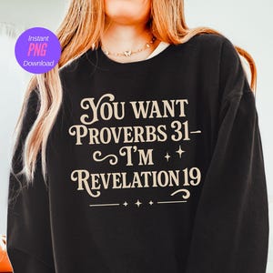 Puede incluir: Sudadera negra con el texto crema "You Want Proverbs 31- I'm Revelation 19". El diseño incluye estrellas y adornos. Un círculo púrpura con "Instant PNG Download" está en la parte superior izquierda.