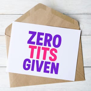 May include: A white card with the text "ZERO TITS GIVEN" in purple and pink, inside a brown envelope. The card is centered, with the envelope partially visible.