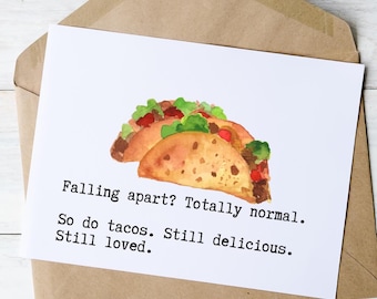 May include: A white greeting card with a watercolor illustration of two tacos, filled with meat, lettuce, and tomatoes. The card reads, "Falling apart? Totally normal. So do tacos. Still delicious. Still loved."