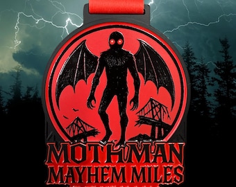 May include: A circular metal medal featuring a black silhouette of a winged creature with glowing red eyes against a red background. The text reads MOTHMAN MAYHEM MILES 1M 5K 10K 13.1 26.2. The medal includes a red ribbon attached to the top.