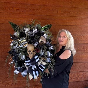 May include: A black and white Halloween wreath with a skull, a witch's hat, and a sign that says "Boo Ghost".