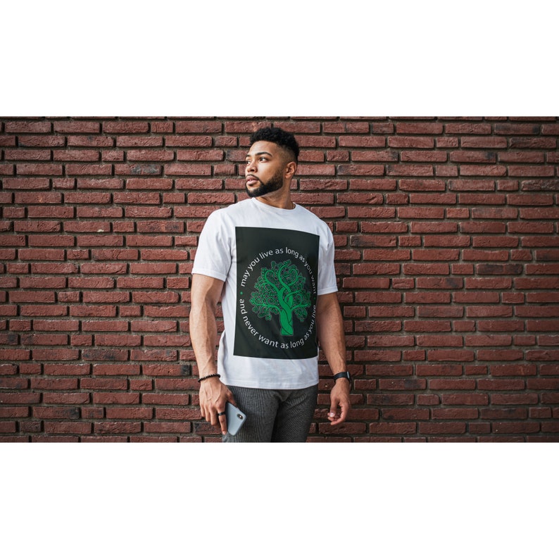 May include: White t-shirt with a black square graphic featuring a green tree and the text "may you live as long as you want and never want as long as you live."
