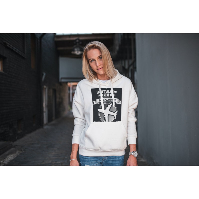 May include: White hoodie with a black and white graphic print that says "I don't always stop for airplanes".