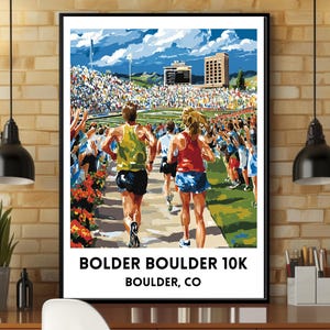 May include: A framed poster featuring a vibrant illustration of the Bolder Boulder 10K race. The artwork depicts runners in motion, cheered on by a crowd, with the race name and location, Boulder, CO, prominently displayed in bold text.