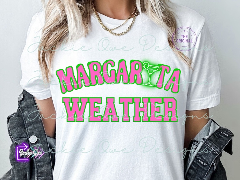 May include: A white t-shirt with the text "Margarita Weather" in pink letters with a green outline. A green margarita glass with a pink drink is above the text.