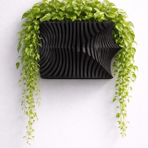 May include: A white ceramic mug with a black handle and the text "But First, Coffee" in a black, handwritten-style font. The mug is on a white surface.