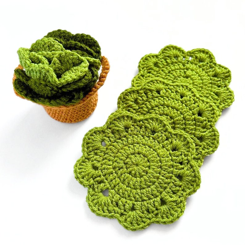 May include: Set of four green crocheted coasters with scalloped edges. The coasters are stacked on top of each other.