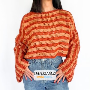 May include: A long-sleeved crochet sweater featuring horizontal stripes in alternating shades of burnt orange and light peach. The garment has a loose, relaxed fit with wide sleeves and a round neckline. Text on the image reads PDF PATTERN.