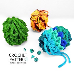 May include: Three crocheted dice bags in green, blue and orange. The bags are made with a textured stitch and have drawstrings. The bags are surrounded by dice.