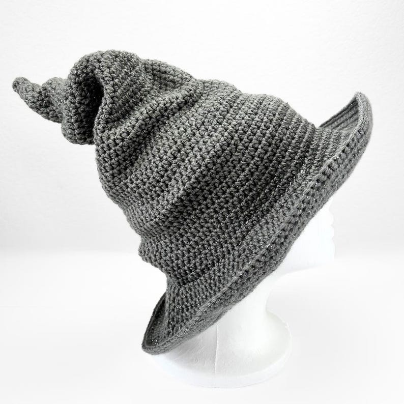 May include: A gray crocheted wizard hat with a pointed brim and a long, curled brim.