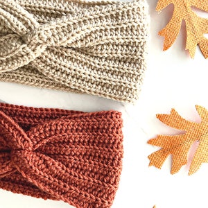 May include: Two crocheted headbands, one in a light brown color and one in a burnt orange color. Both headbands have a twisted knot design.