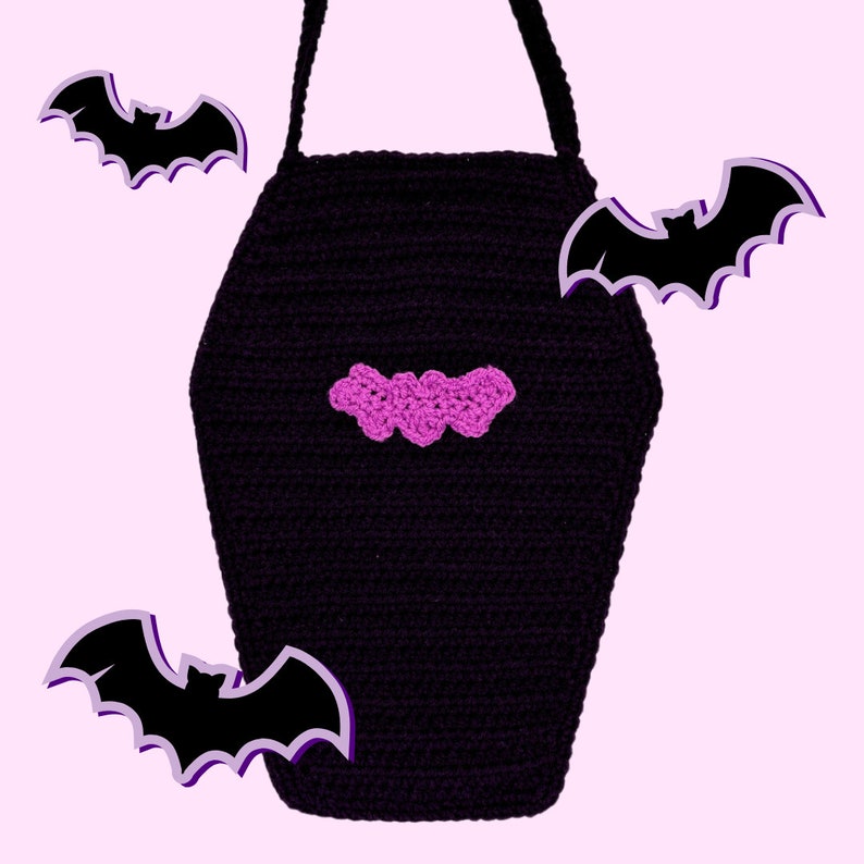 May include: A black crocheted bag shaped like a coffin with a single strap. The front of the bag features a small, pink crocheted bat appliqu&eacute;. Three additional black bat illustrations with light purple outlines are positioned around the bag.
