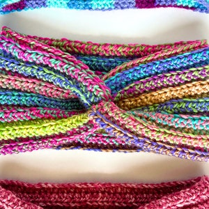 May include: Three crocheted headbands in different colors and patterns. The top headband is blue, purple, and turquoise. The middle headband is a multi-colored stripe pattern. The bottom headband is a solid pink.