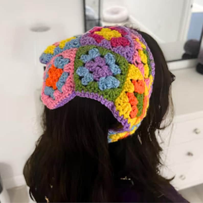 Puede incluir: Una diadema de crochet colorida con un patr&oacute;n de cuadrados de la abuela en tonos de rosa, morado, azul, verde, amarillo y naranja.
