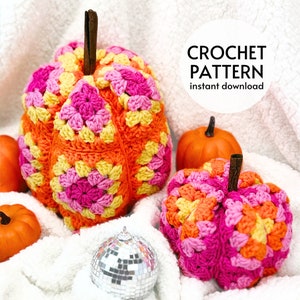 May include: Crocheted pumpkins in shades of orange, pink, and yellow, with a cinnamon stick stem. The pumpkins are set on a white, fluffy surface. The image includes the text "CROCHET PATTERN instant download".