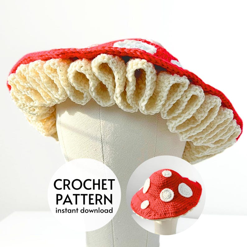 May include: Crochet pattern for a red and white mushroom hat. The pattern is available for instant download. The image shows a crocheted mushroom hat on a white mannequin head. The hat has a red top with white polka dots and a white crocheted ruffle around the bottom.
