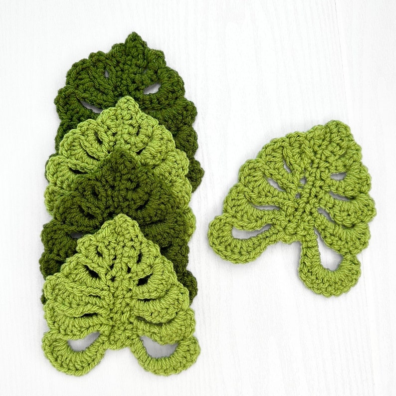 May include: Five crocheted green leaf coasters with a single leaf coaster in the same style.