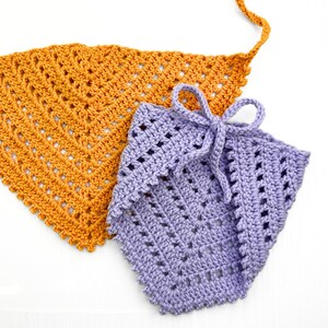 Puede incluir: Dos bufandas triangulares de ganchillo, una de color naranja claro y otra de color morado claro. Las bufandas est&aacute;n hechas con un delicado patr&oacute;n de punto abierto.