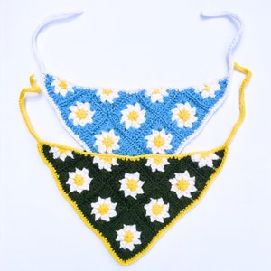 Puede incluir: Dos bandanas de crochet con patrones de flores de margarita. La bandana superior es azul claro con flores blancas. La bandana inferior es verde oscuro con flores amarillas.