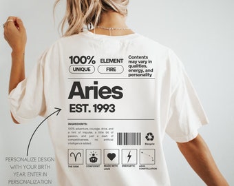 Op de afbeelding: Wit T-shirt met een zwart grafisch ontwerp met het sterrenbeeld Ram, de tekst "100% Unique Element Fire", "Aries", "Est. 1993" en een lijst met ingrediënten. De tekst "Personaliseer het ontwerp met je geboortejaar. Voer het in in de personalisatie wanneer je het aan je winkelwagen toevoegt of je kunt "jaar verwijderen" invoeren" is ook inbegrepen. Het model draagt maat XL in de kleur ivoor.