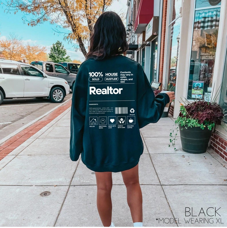 May include: Black sweatshirt with a white graphic design that says "100% House Hustler Sold Realtor". The graphic design resembles a product label with a barcode and other details.