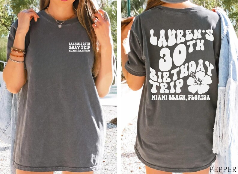 May include: A gray t-shirt with white text that says "Lauren's 30th Birthday Trip Miami Beach, Florida" on the back. The front of the shirt has the text "Lauren's 30th Bday Trip Miami Beach, Florida".