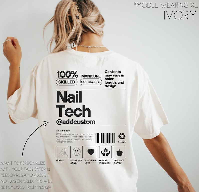 Pu&ograve; includere: Maglietta bianca con un design grafico nero che dice "100% Skilled Manicure Specialist Nail Tech @addcustom". Il design grafico &egrave; nello stile di un'etichetta di prodotto con un elenco di ingredienti e un simbolo di riciclaggio. La maglietta &egrave; indossata da un modello.