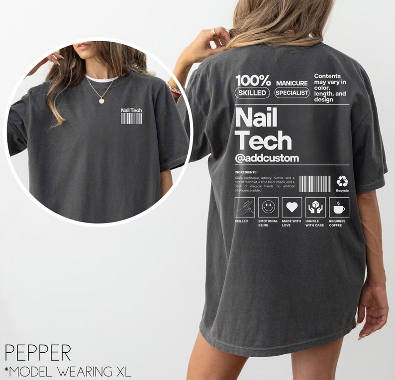 Pu&ograve; includere: Una maglietta oversize grigio scuro con una stampa grafica bianca che dice "100% Skilled Manicure Specialist Nail Tech @addcustom". La grafica include anche un elenco di ingredienti, tra cui "tecnica, umorismo, un pizzico di malizia, un po' di caos e un pizzico di mani magiche. Nessuna intelligenza artificiale aggiunta." La grafica include anche icone per "competente", "essere emotivo", "fatto con amore", "maneggiare con cura" e "richiede caff&egrave;".