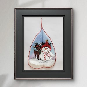 以下が含まれることがあります： 額装されたアートワークで、気まぐれなクリスマスのシーンが特徴です。赤い帽子とスカーフを着た雪だるまが、シルクハットをかぶったトナカイと一緒に立っており、雪が降る青い葉の形をした背景を背景にしています。アートワークは「MeenaArts」と署名されています。