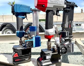 May include: Two cordless nail guns. One is blue and black, the other is red, silver, and black. Both are mounted on black battery packs. The red and silver nail gun has the brand name "Ronix" printed on it.