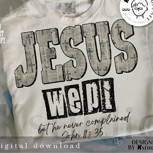 May include: Cream-colored t-shirt with the words "JESUS WEPT" in a distressed newspaper print style. The text "but he never complained John 11:35" is printed below. The shirt also has a "digital download" label.