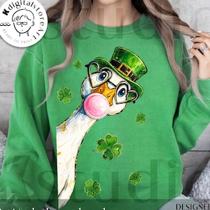 May include: Green sweatshirt with a cartoon goose wearing a green leprechaun hat and heart-shaped glasses, blowing a pink bubblegum bubble. Shamrock graphics are scattered across the design. The words "digital download" are at the bottom.