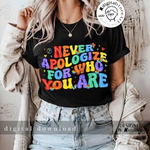 Puede incluir: Una camiseta negra con un gráfico de arcoíris que dice "Nunca te disculpes por quién eres".