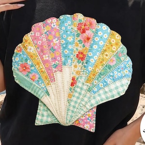 Puede incluir: Camiseta negra con un diseño de concha marina colorida con patrones florales y de cuadros. La camiseta tiene el texto "digital download" y "DESIGNED BY Kstudio". La imagen también incluye el texto "PRINTABLE PNG NO STITCH FILE FAUX EMBROIDERY NO INSTRUCTIONS".