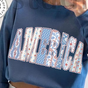 May include: A blue sweatshirt with the word "AMERICA" in a floral and polka dot design. The sweatshirt has long sleeves and a crew neck. The words "digital download" and "designed by Kstudio" are also visible.